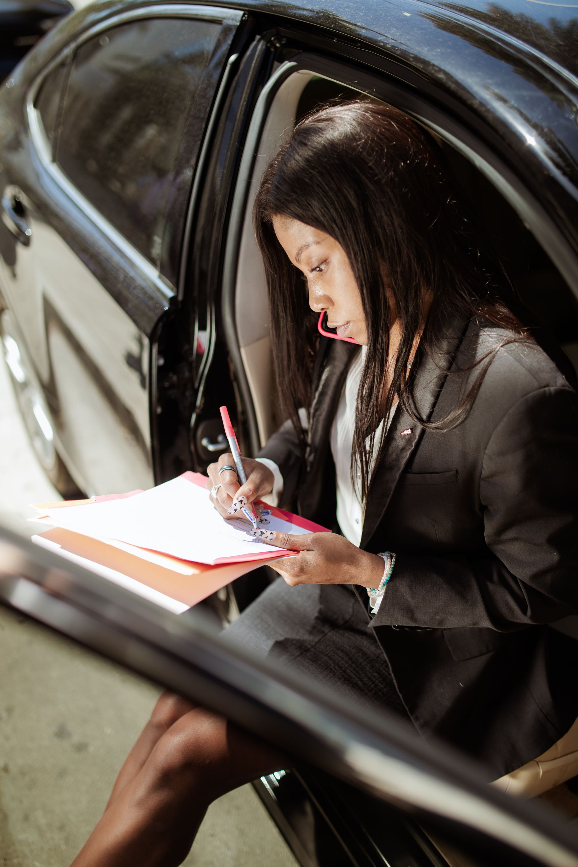 Woman completing paperwork while seated in a parked car